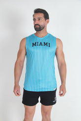A male model wearing a turquoise and navy pinstripe muscle tank top with MIAMI printed on the chest and black shorts.