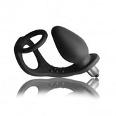 Black silicone adult novelty with a bulbous plug, ring, and textured connecting strap on a reflective surface.