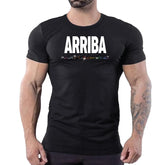 A muscular man wearing a black t-shirt with ARRIBA in white text and rainbow lettering underneath.