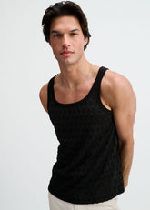 A man wearing a black ST33LE stretch ripped knit tank top and a thin silver chain necklace against a light background.