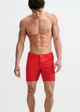 A shirtless man wears ST33LE red stretch knit shorts against a plain white background.