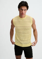 A man wearing a ST33LE cream-colored open-knit pointelle tank top and dark shorts, posing against a white background.