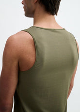 Back view of a man wearing a textured army green performance tank top.