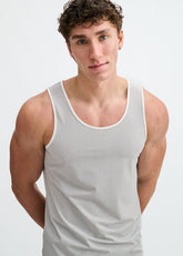 A male model wearing a ST33LE white and black textured stretch mesh performance tank top.
