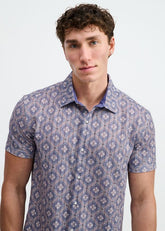 Model wearing ST33LE short-sleeve button-down shirt in blueberry and petal with a diamond print.