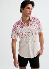 A man wearing a ST33LE blush and fuchsia short-sleeve button-down shirt with a floral engineered border print.