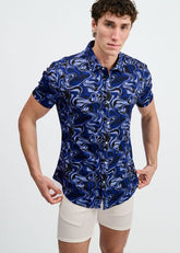 A male model wearing a ST33LE short-sleeve button-down shirt with a navy and thistle abstract swirl print.