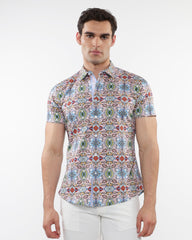 A man wearing a fauna print stretch knit short-sleeved shirt with colorful geometric patterns in blue green red and beige