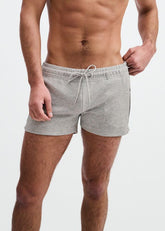 Shirtless man wearing ST33LE grey gym shorts with a drawstring waist and contrast piping, against a white background.