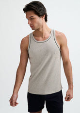 A man wearing a grey rib-stretch ringer tank top with black piping detail against a white background.