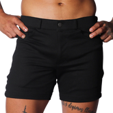 Slim-fit black shorts in a smooth, durable fabric with belt loops, a single button closure, and front pockets.