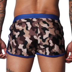 Men's camouflage beach shorts with a solid blue elastic waistband and blue trim on the curved side hems.