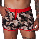 Men's camo beach shorts with red trim, drawstring waistband, and side pockets in a short athletic fit.