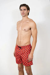 Red swim trunks with a black and white toucan print pattern for stylish beachwear and swimming