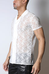 A model wearing a white Timoteo Windsor short-sleeve lace button-down shirt and black pants in profile view.