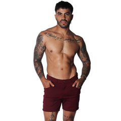Wine-colored tailored shorts featuring a flat front, button closure, and slim-fit silhouette.