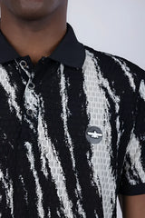 Black and white abstract polo shirt with textured fabric and circular logo patch on the chest