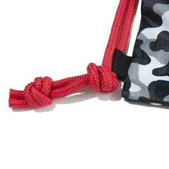 Red braided drawstring with knotted end attached to black and gray camouflage fabric of addicted camo backpack bag charcoal adf90
