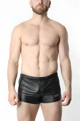 Black shiny faux leather anti-chrome gear short with subtle logo on the lower right leg
