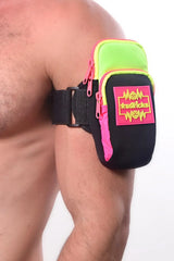 Neon green and pink athletic arm bag with black straps featuring a bold m*sssticks logo patch for sports use