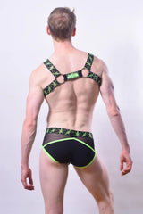 Black and neon green patterned men’s lingerie stinger brief with starburst design and breathable fabric