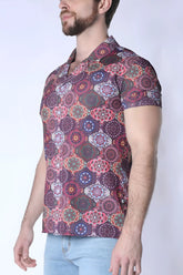 A man wearing a balboa button down shirt with a multicolored mandala pattern in purple pink and green