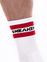White athletic sneaker half sock by barcode berlin with bold red stripe and black lettering on the cuff size s/m