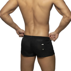 Back view of basic mini short black athletic shorts with a white logo on the back pocket for casual wear