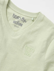 A light green cotton v neck born fly tee with subtle embroidered logo on the chest and matching collar tag