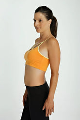 Orange sports bra top with cream trim and thin straps designed for activewear and comfort
