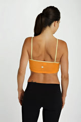 Bra top tangerine showing the back side in orange with thin matching yellow straps and a small brand logo