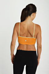 Bra top tangerine showing the back side in orange with thin matching yellow straps and a small brand logo