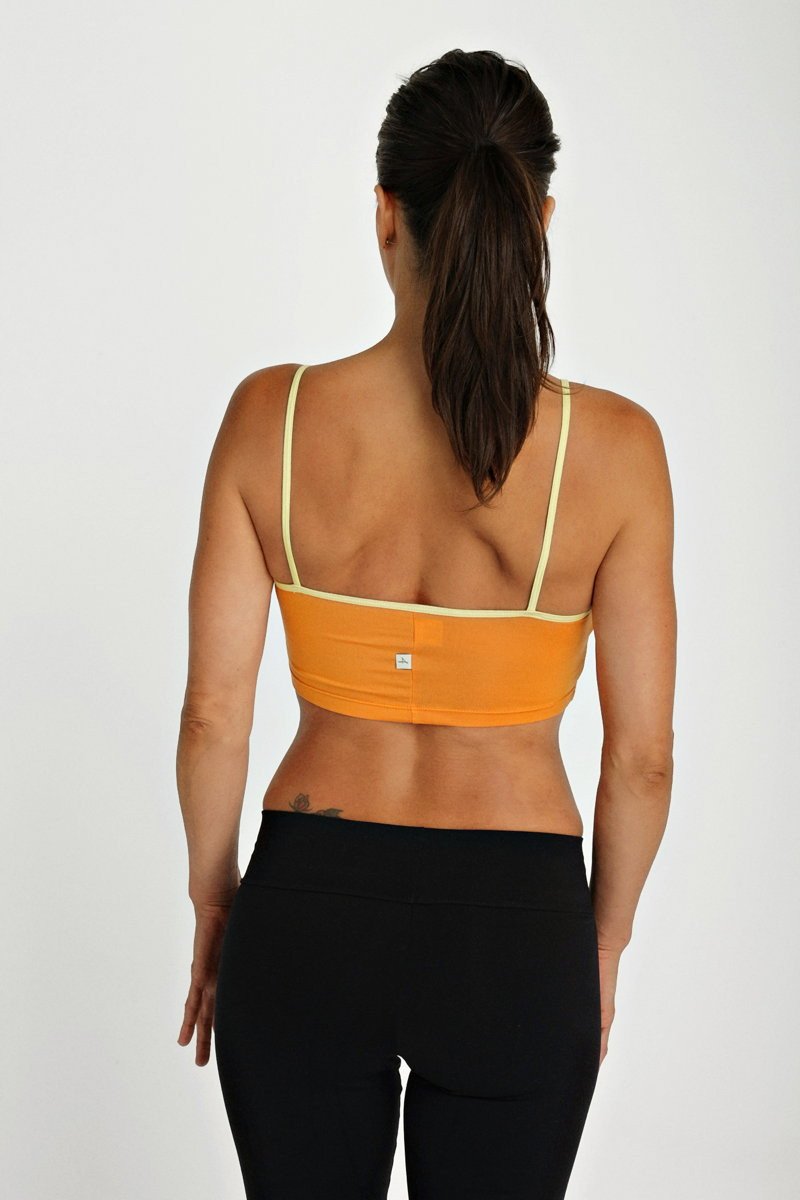 Back view of orange bra top tangerine with pale yellow straps and a small white logo on the back