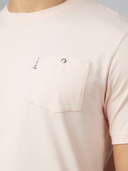 A soft blush pink signature t shirt with chest pocket featuring silver button closure and branded tag on upper left corner
