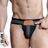 Black and gray bulger jockstrap with orange big dick logo patch and subtle striped pattern on the side waistband