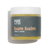 A matte white jar of pure for men bum balm with a dark gray label containing yellowish-green mint and clove balm