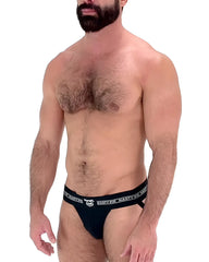 Black nasty pig brand briefs core jockstrap with white logo and text on waistband designed for support and comfort