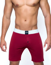 Red men’s boxer shorts with white elastic waistband featuring black text and branding from core series lounge short