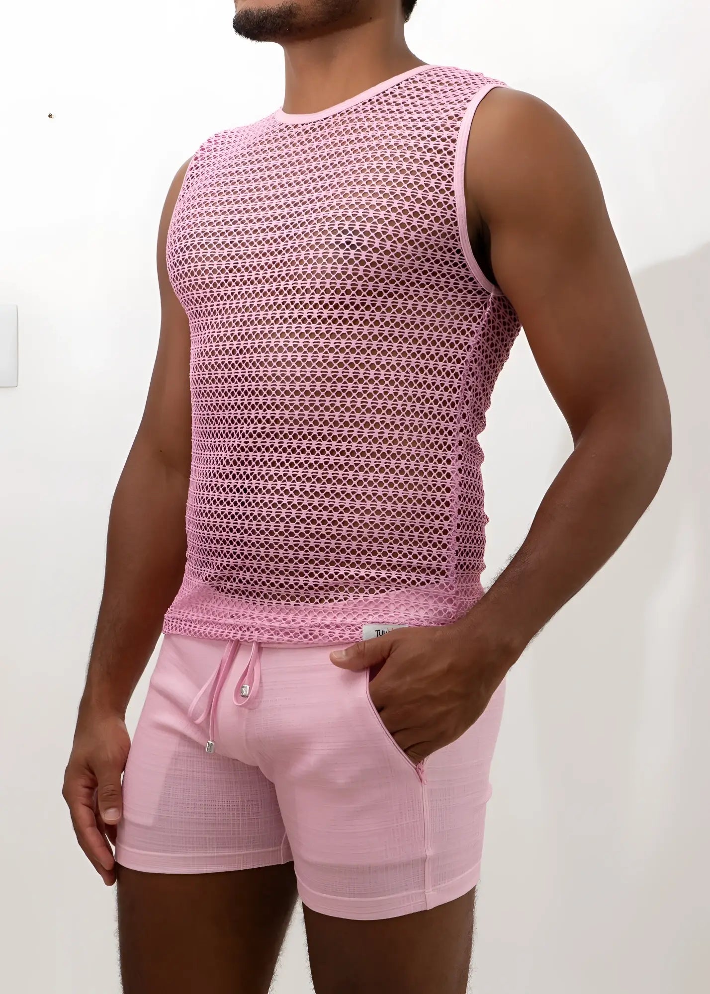 Pink crochet muscle tank top with mesh sleeveless design and subtle geometric pattern paired with matching drawstring shorts