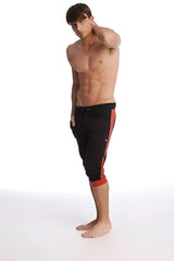 Black cuffed yoga pants with red cinnabar side stripes and a drawstring waistband in capri length