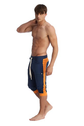 Cuffed yoga pants in royal blue and orange with navy blue and orange athletic shorts featuring a white drawstring
