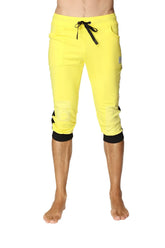 Bright yellow cuffed yoga pants with black drawstring waist, elastic cuffs, and side pockets in capri length