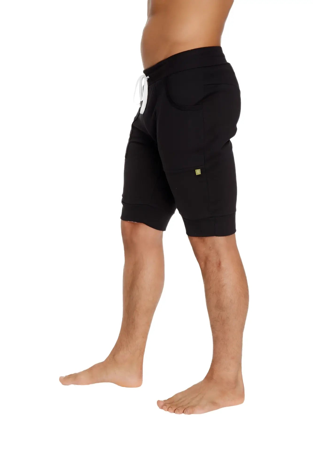 Black cuffed yoga shorts with white drawstring and small green logo made of cotton for casual comfort