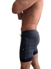 Dark gray and black two-tone cuffed yoga shorts with ribbed waistband side pockets and contrasting trim for athletic use