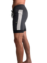 Dark gray cuffed yoga shorts with textured silver stripe and black drawstring waistband for athletic wear