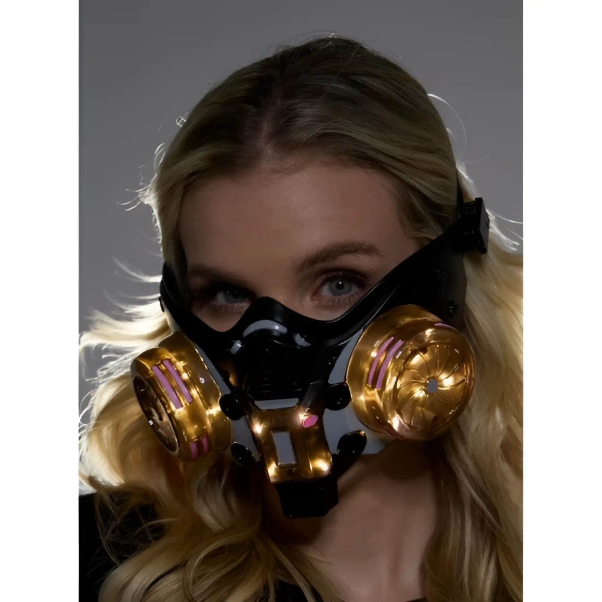 Black and gold cyberpunk light up mask with glowing pink accents on circular filters for futuristic style