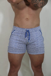 Designer print linen texture shorts featuring blue and white geometric patterned swim trunks with a matching drawstring waistband
