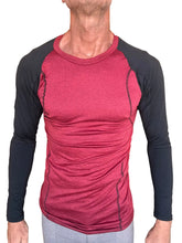 A men’s designer raglan crew-neck long sleeve tee with a red heathered torso and black sleeves featuring subtle seams