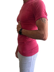A person wearing a vibrant raspberry designer raglan crew-neck tee with subtle ribbed texture and short sleeves