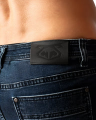 Black leather patch with embossed logo on the back of dark blue denim duke short jeans